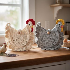 May include: Two crochet chicken-shaped bags in cream and gray, with red and yellow accents. Each bag has a scalloped edge and a wooden button closure. The bags are displayed on a wooden surface.