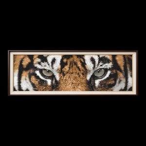 May include: A framed artwork featuring a close-up of a tiger's face, showcasing its eyes and facial markings. The artwork is dominated by shades of brown, black, and white, with the tiger's eyes in shades of green. The frame is a dark brown color.
