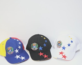 May include: Three baseball caps with a colourful Venezuelan flag design. Each cap features a yellow, blue and red colour scheme with a white star pattern and a small embroidered coat of arms.