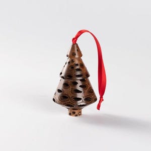 Op de afbeelding: Een houten kerstboomversiering met een bruin en zwart patroon. De versiering heeft een rood lint aan de bovenkant.