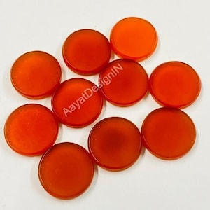 May include: Ten round, orange, translucent, gemstone cabochons. The cabochons are smooth and polished.