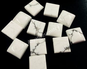 May include: A collection of ten white howlite cabochons with gray veining. The cabochons are square shaped and have a smooth, polished finish.