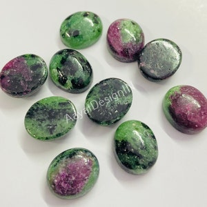 Puede incluir: Diez piedras preciosas ovaladas de color verde, negro y rosa. Las piedras preciosas tienen un acabado liso y pulido.