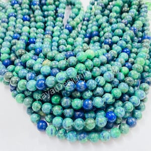 May include: A strand of green and blue gemstone beads. The beads are round and have a mottled appearance.