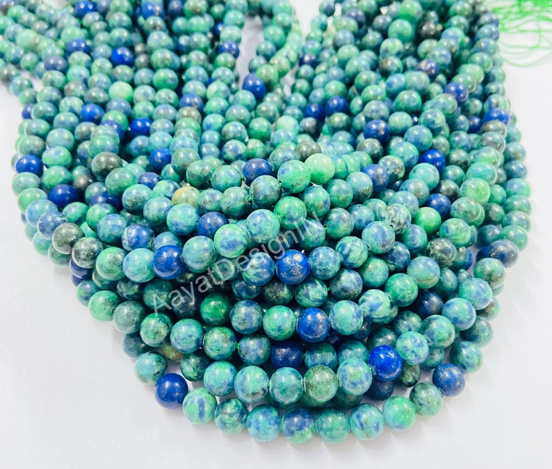 May include: A strand of green and blue gemstone beads. The beads are round and have a mottled appearance.