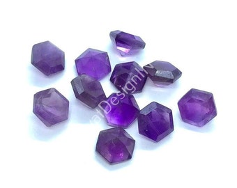 Könnte beinhalten: Zehn facettierte Amethyst-Edelsteine in sechseckiger Form. Die Edelsteine sind tiefviolett und haben eine glänzende Oberfläche.