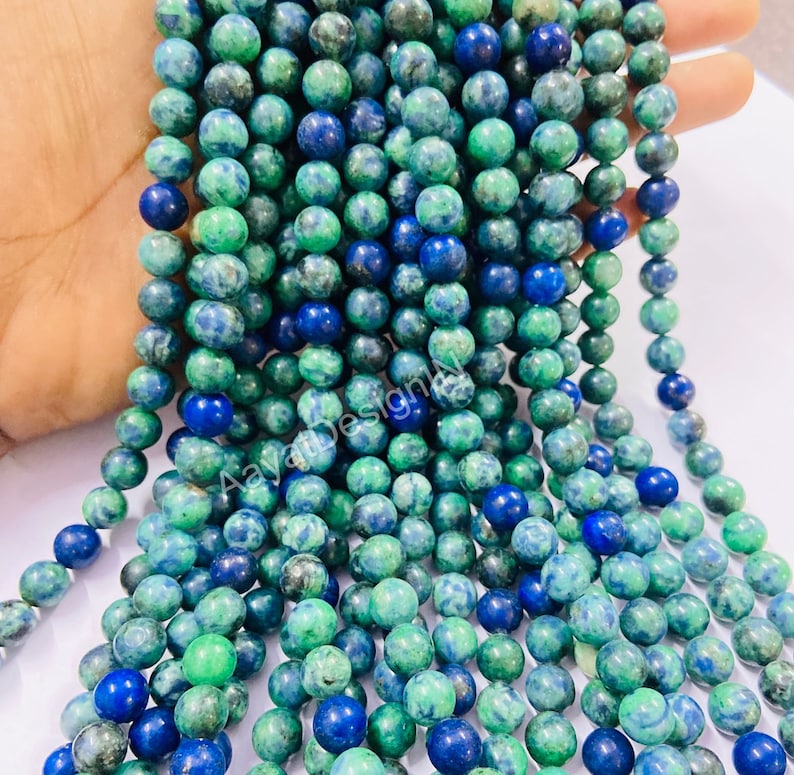 May include: A strand of green and blue gemstone beads. The beads are round and have a mottled appearance.