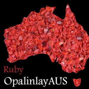 May include: An outline of the continent of Australia filled with small, red ruby gemstones. The text "Ruby Opal inlayAUS" is below the image.