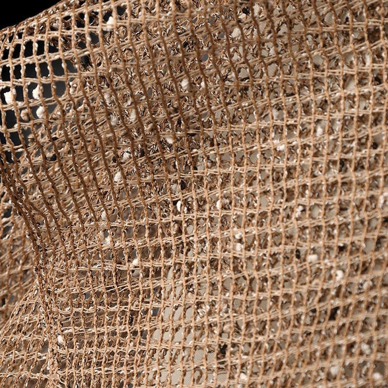 Puede incluir: Primer plano de una tela de malla tejida marr&oacute;n con un patr&oacute;n de cuadr&iacute;cula. La tela tiene una textura ligeramente rugosa y est&aacute; hecha de fibras naturales.
