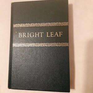 以下が含まれることがあります： 表紙に金色の文字で「BRIGHT LEAF」と書かれた、濃い緑色のハードカバーの本です。