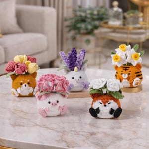 May include: Five crocheted animal planters, each with crocheted flowers. The planters are shaped like a Shiba Inu, a pig, a fox, a tiger, and a unicorn. The flowers include tulips, lavender, and roses. The planters are decorative.