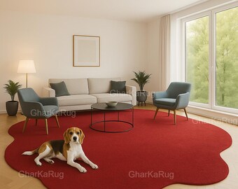 May include: A large, solid red area rug with an irregular, organic, cloud-like shape. The rug is placed on a light-colored wooden floor in a room featuring a beige sofa, two blue armchairs, a black coffee table, and a beagle dog lying down.