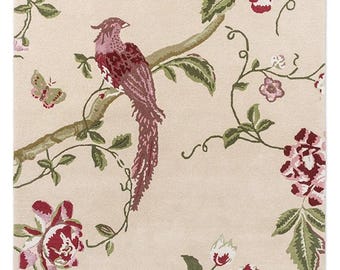 May include: A rectangular area rug with a light beige background featuring a repeating pattern of deep red and pink flowers, green leaves, and a central bird with long tail feathers perched on a branch, accompanied by a small butterfly.