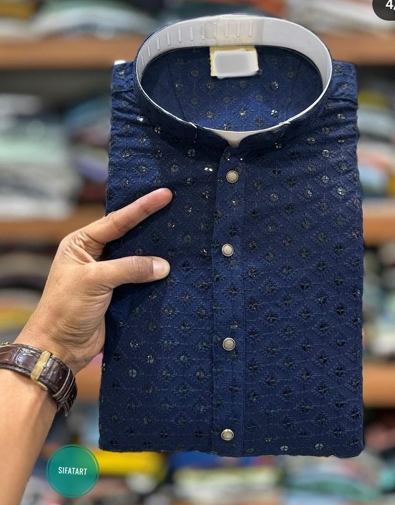 K&ouml;nnte beinhalten: Eine marineblaue Kurta mit wei&szlig;em Kragen und aufwendigen Stickereien. Die Kurta hat einen Knopfverschluss und ein traditionelles Design.