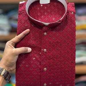 K&ouml;nnte beinhalten: Eine bordeauxrote Kurta mit Knopfleiste und geometrischem Muster. Die Kurta ist aus leichtem Stoff und hat eine lockere Passform.