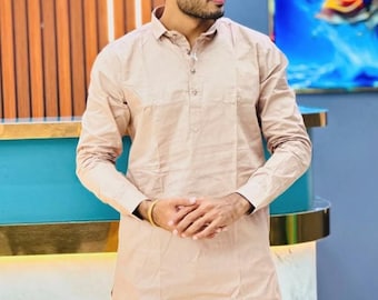 May include: A man wearing a light brown long-sleeved kurta with a button-up collar. He is wearing white pants and black sunglasses. The text "Sifatart" is visible in the bottom left corner of the image.