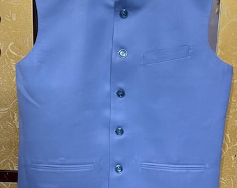 May include: A light blue vest with a mandarin collar and a button-down front. The vest has two front pockets and the text "Sifatart" in green cursive. The vest is sleeveless and appears to be made of a smooth fabric.