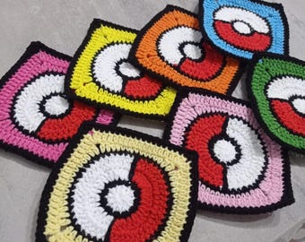 Puede incluir: Una colección de posavasos de ganchillo coloridos en varios colores, incluyendo rosa, amarillo, naranja, azul y verde. Cada posavasos presenta un diseño circular blanco y rojo con un borde negro, que se asemeja a un gráfico estilizado.
