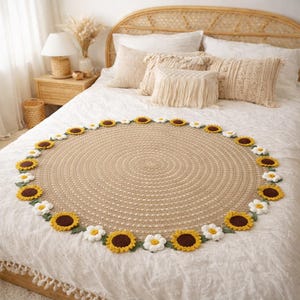 May include: A round, beige crochet rug with a sunflower and daisy border. The sunflowers have yellow petals and brown centers, while the daisies are white with yellow centers. The rug is placed on a white bedspread.