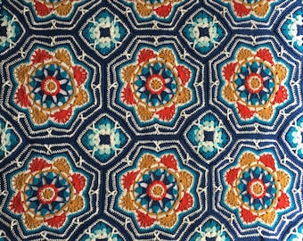 May include: A crocheted blanket featuring a geometric design in shades of blue, red, orange, and white.