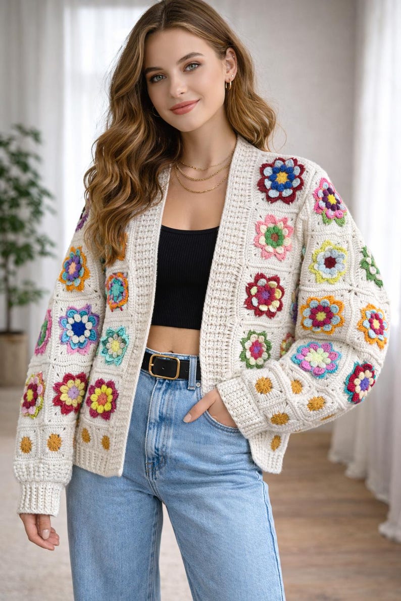 Puede incluir: C&aacute;rdigan de crochet color crema con cuadrados florales coloridos. El su&eacute;ter abierto presenta un cintur&oacute;n negro, un top negro y vaqueros azules. Los cuadrados florales son en tonos rojos, azules, amarillos y rosas.