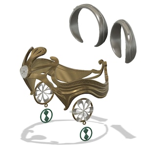 May include: A gold-colored metal crown with intricate details, including two wheels with flower-shaped designs and two dangling green diamond-shaped charms. Two silver-colored metal rings are also included.