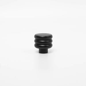 Puede incluir: Un pomo de armario negro con un dise&ntilde;o cil&iacute;ndrico apilado. El pomo presenta tres secciones redondeadas y una parte superior plana, montada sobre una base cil&iacute;ndrica corta. El herraje es de un material negro mate s&oacute;lido.