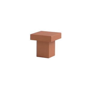 K&ouml;nnte beinhalten: Ein quadratischer Schrank-Knopf in Terrakotta-Farbe mit leicht erh&ouml;hter Oberseite.