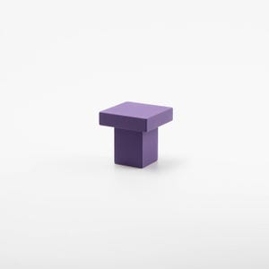 K&ouml;nnte beinhalten: Ein quadratischer Schrank-Knopf in Lila mit quadratischer Basis.