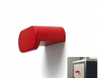May include: A solid red, rounded rectangular cabinet knob with a smooth finish. The knob features a protruding, horizontal design that extends outward from the mounting surface, shown installed on a cream-colored drawer with a dark blue frame.