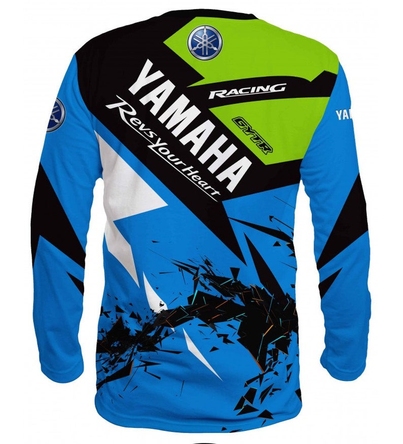 Puede incluir: Una camiseta de manga larga azul, negra, blanca y verde con un dise&ntilde;o gr&aacute;fico que presenta el logotipo de Yamaha y el texto "Yamaha Racing GYTR Revs Your Heart".