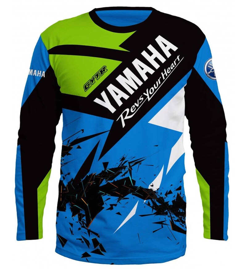 Puede incluir: Una camiseta de manga larga azul, negra, blanca y verde con un dise&ntilde;o gr&aacute;fico que presenta el logotipo de Yamaha y el texto "Yamaha Revs Your Heart".