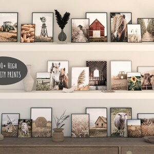 May include: A collection of framed prints featuring various farm and nature scenes, including horses, barns, tractors, and sunflowers. The prints are arranged on a white shelf with a wooden top. The text "1200+ HIGH QUALITY PRINTS" is displayed on a black and white label.