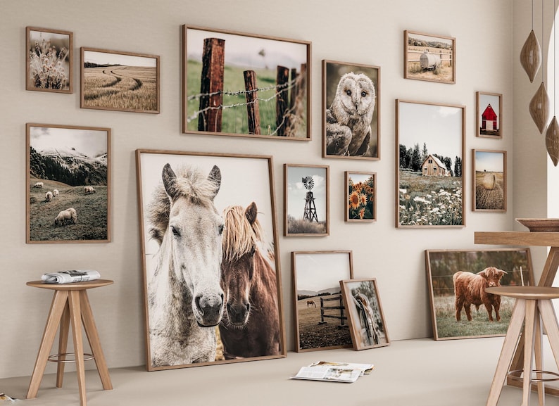 May include: A gallery wall featuring framed prints of various farm and nature scenes, including horses, a barn, a windmill, sunflowers, and a field of hay bales.