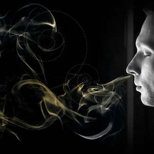 Puede incluir: Un hombre inhala profundamente, con una columna de humo que gira alrededor de su rostro. El humo es una mezcla de blanco y dorado, creando una imagen visualmente impactante.