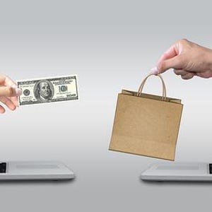 May include: Two laptop computers with hands reaching out of the screens. One hand is holding a $100 bill and the other hand is holding a brown paper shopping bag.