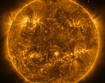 May include: A close-up image of the sun, showing its surface with a bright, golden-orange colour and a textured, swirling pattern. The sun's corona, or outer atmosphere, is visible as a faint halo around the sun.