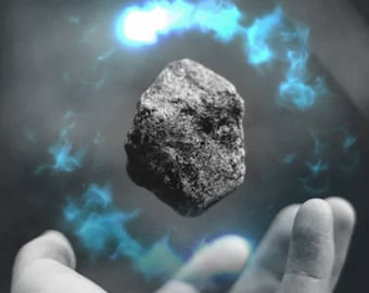 May include: A hand levitates a dark gray rock with a blue glow emanating from the hand and rock.