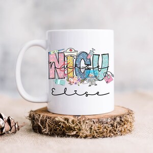 Puede incluir: Taza de cer&aacute;mica blanca con un dise&ntilde;o colorido que dice "NICU" con ilustraciones m&eacute;dicas y el nombre "Elise" escrito en negro debajo.