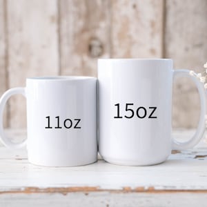 May include: Two white ceramic mugs with black text. The smaller mug is 11 oz and the larger mug is 15 oz.