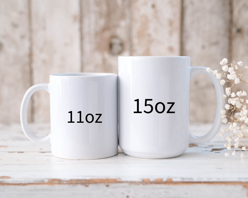 May include: Two white ceramic mugs with black text. The smaller mug is 11 oz and the larger mug is 15 oz.