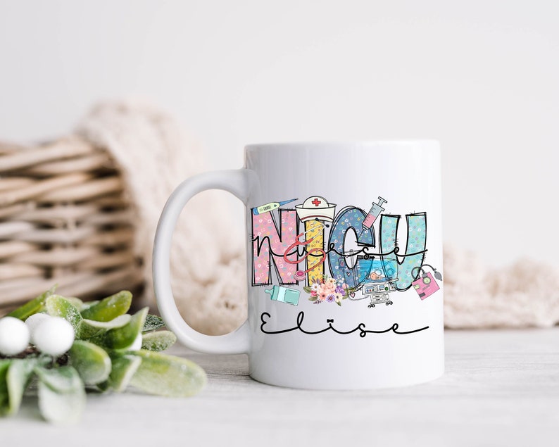 Puede incluir: Taza de cer&aacute;mica blanca con un dise&ntilde;o colorido que dice "NICU Elise". El dise&ntilde;o presenta s&iacute;mbolos m&eacute;dicos y flores.