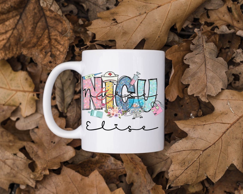 Puede incluir: Taza de cer&aacute;mica blanca con un dise&ntilde;o colorido que dice "NICU Nurse" con un estetoscopio, una jeringa y otros equipos m&eacute;dicos. El nombre "Elise" est&aacute; escrito en cursiva debajo del dise&ntilde;o.