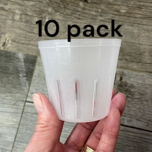 Może przedstawiać: Opakowanie 10 przezroczystych plastikowych doniczek z otworami drenażowymi. Doniczki mają średnicę 10 cm i wysokość 10 cm.