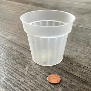 Peut inclure: Un gobelet en plastique transparent avec un motif côtelé. Le gobelet est à peu près de la taille d'une pièce de 1 centime d'euro.