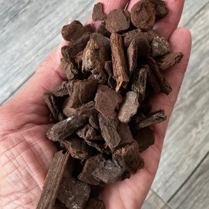Puede incluir: Un puñado de virutas de madera de color marrón oscuro, algunas de las cuales son largas y delgadas, mientras que otras tienen formas más irregulares.