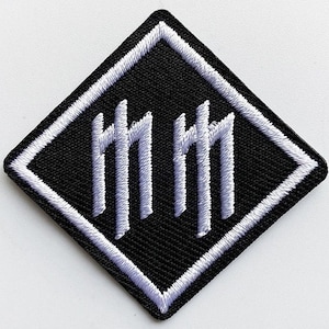 May include: Black embroidered patch in a diamond shape with a white border. The patch features a stylized design of three vertical lines with horizontal crossbars, repeated twice.