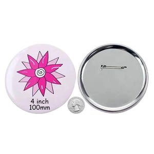 Puede incluir: Un botón de 100 mm (4 pulgadas) con un diseño de flor rosa sobre un fondo blanco. La parte posterior del botón es plateada con un alfiler.