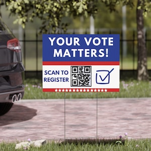 May include: A rectangular yard sign with the message "YOUR VOTE MATTERS!" in white text on a blue background. It includes a QR code and the text "SCAN TO REGISTER". A checkmark is next to the QR code. The sign is supported by a metal frame.