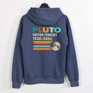 May include: A navy blue hooded sweatshirt with a vintage-style graphic on the back. The graphic features the word "PLUTO" in rainbow colors, the text "NEVER FORGET 1930-2006", and a stylized image of Pluto.